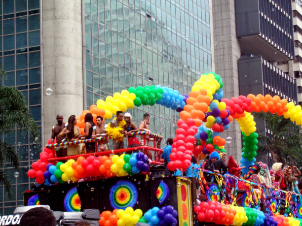 LGBT Pride Parade 2016 in São Paulo, Brazil Parada do Orgulho LGBT scene, 20th edition of the Pride Parade LGBT, May 29, 2016, on Avenida Paulista, in São Paulo, Brazil, with electric trio car with colorful balloons and costumes. The theme of the year for the event was 'Gender identity law, now! - All people together against Transphobia!'. The concentration for the beginning of the event was in front of the Masp, Museum of Art of São Paulo. The event is known worldwide, aims to promote respect for sexual diversity and happens every year on the main avenue of the city, bringing together millions of people. sao paulo gay pride parade stock pictures, royalty-free photos & images
