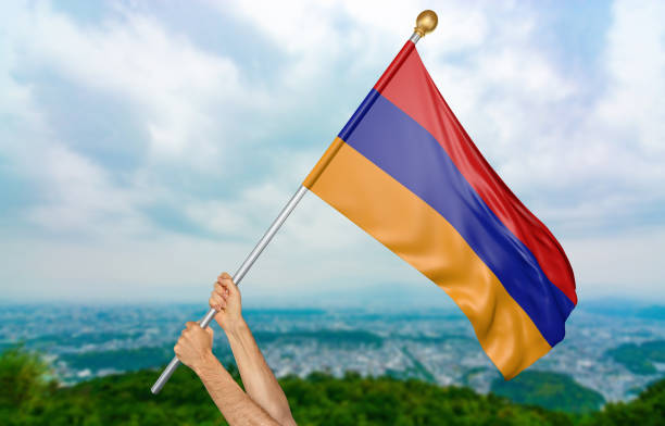 genç adamın elleri gururla ermenistan ulusal bayrak sallayarak - ermeni bayrağı stok fotoğraflar ve resimler