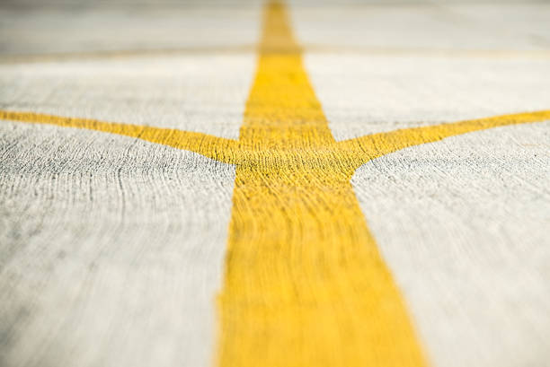 istock Yellow direction strips closeup on an airfield runway. 653577764