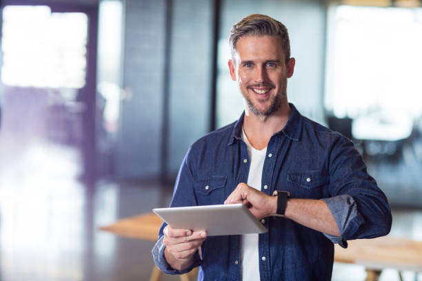 istock Portrait of man holding digital tablet in office 653618538