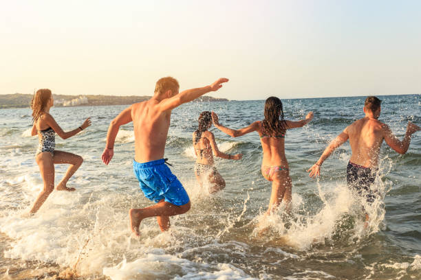istock Friends jumping in sea 653746904