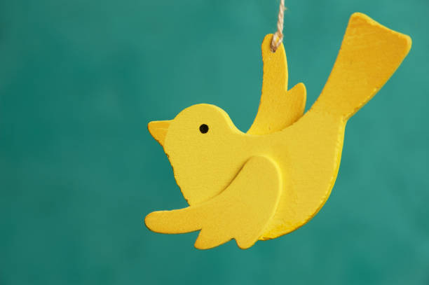 Wooden yellow bird on green background