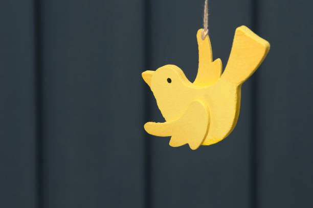 Wooden yellow bird on gray background