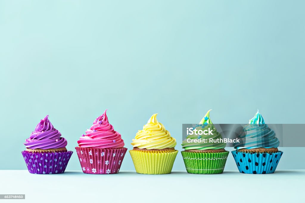 Colorful cupcakes Row of colorful cupcakes on blue Cupcake Stock Photo