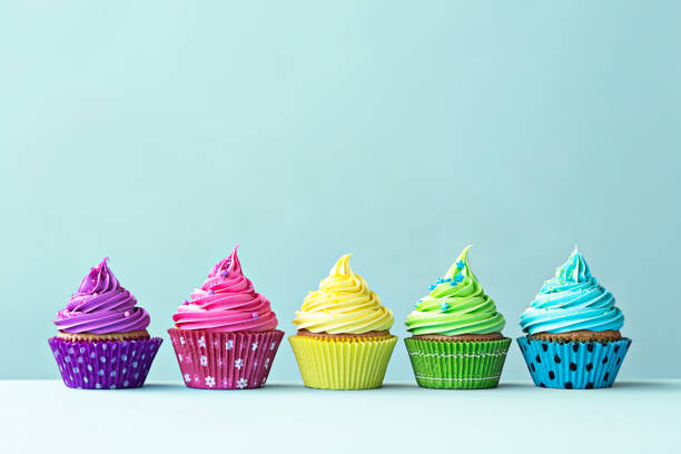 Colorful cupcakes Row of colorful cupcakes on blue cupcake stock pictures, royalty-free photos & images