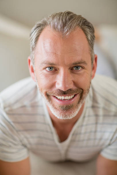 istock Smiling man lying on bed in bedroom 653748786