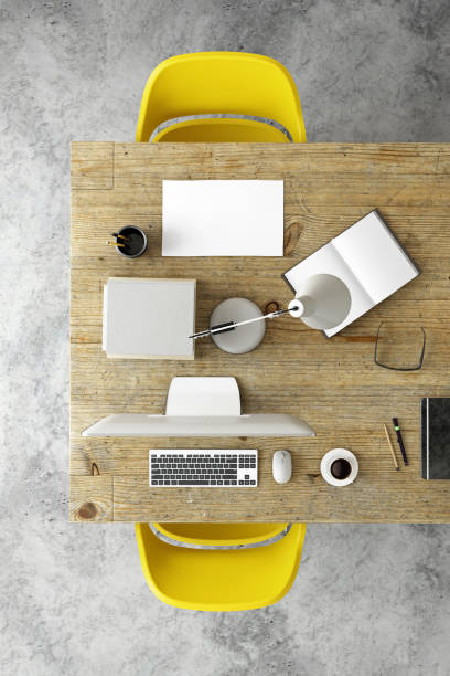 business knolling template, co working space top view. pc monitor on one and paper on the other side. wooden desk, office designer template scene. vertical composition. concrete floor.  yellow chairs. no people