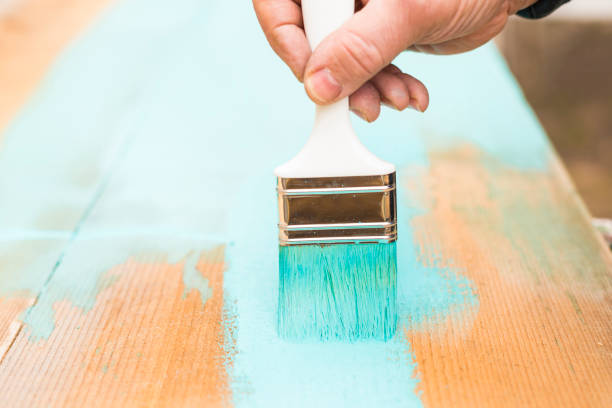 istock Painting a wooden plank using paintbrush 653754290