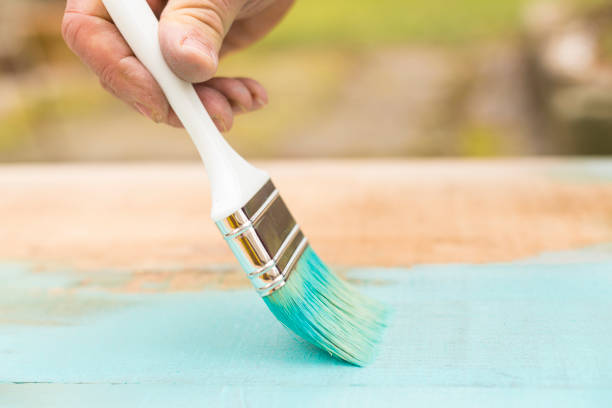 istock Painting a wooden plank using paintbrush 653754386