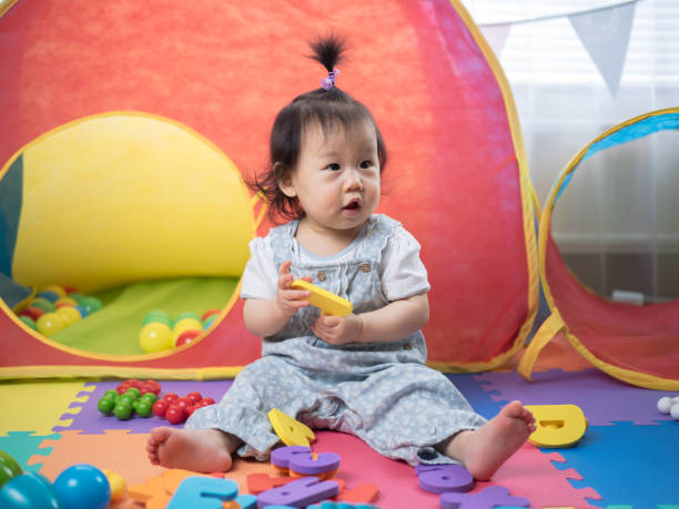 istock baby girl playing alphabet blocks 653754692