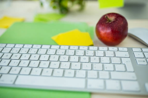 istock Sticky note, apple and keyboard on office desk 653759150