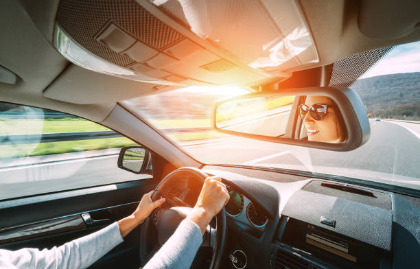 車を運転する女性はバックビューミラーに反映 - car road safety driving ストックフォトと画像