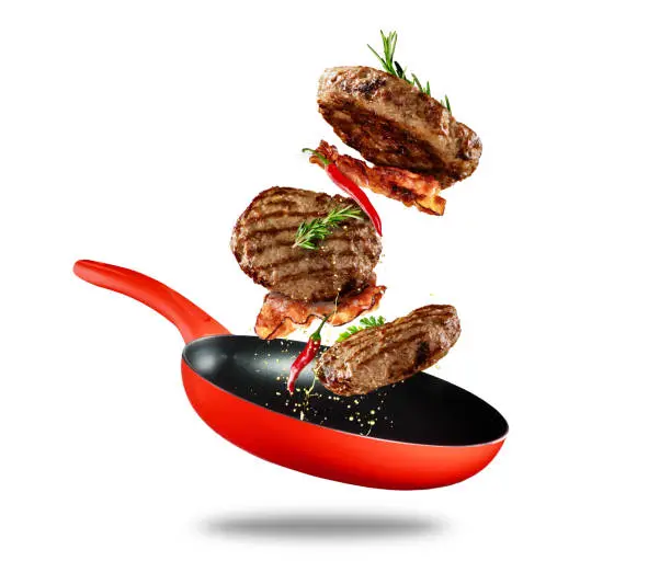 Photo of Beef milled meat flying from a pan on white background