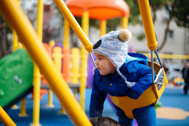 istock Happy baby boy in swing on playground 653761918