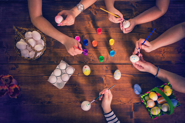 Family preparing for Easter, they painting Easter eggs together at home
