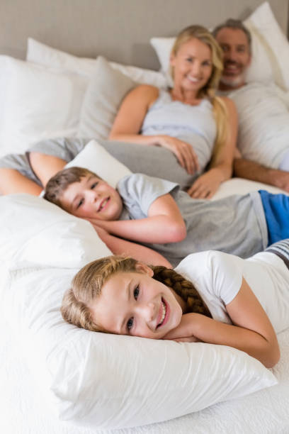 istock Parents and kids relaxing on bed in bedroom 653764324