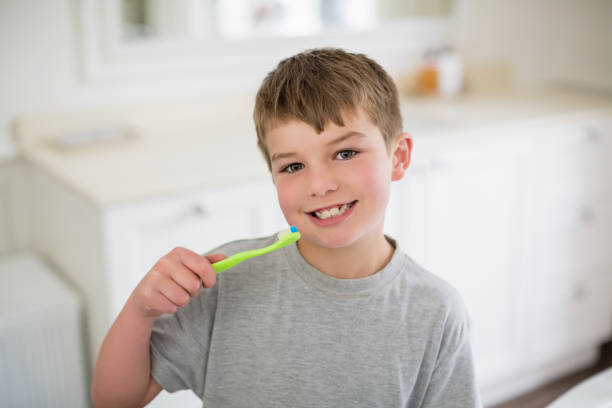 istock Portrait of boy brushing teeth in bathroom 653764776