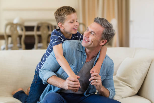 istock Smiling son embracing a father in living room 653765124
