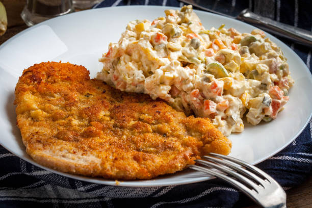 istock Fried pork chop in breadcrumbs, served with vegetable salad. 653767920