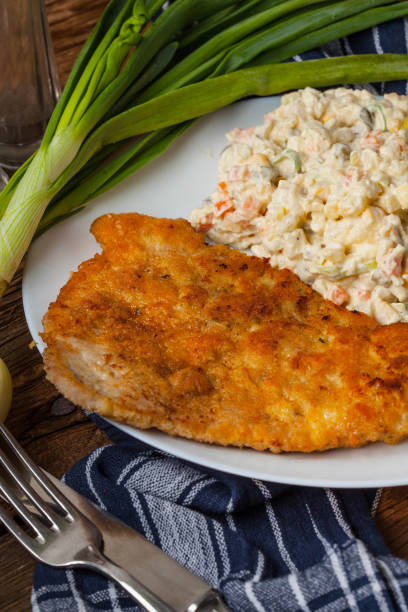 istock Fried pork chop in breadcrumbs, served with vegetable salad. 653767974