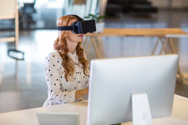 istock Businesswoman using virtual reality headset in office 653769712