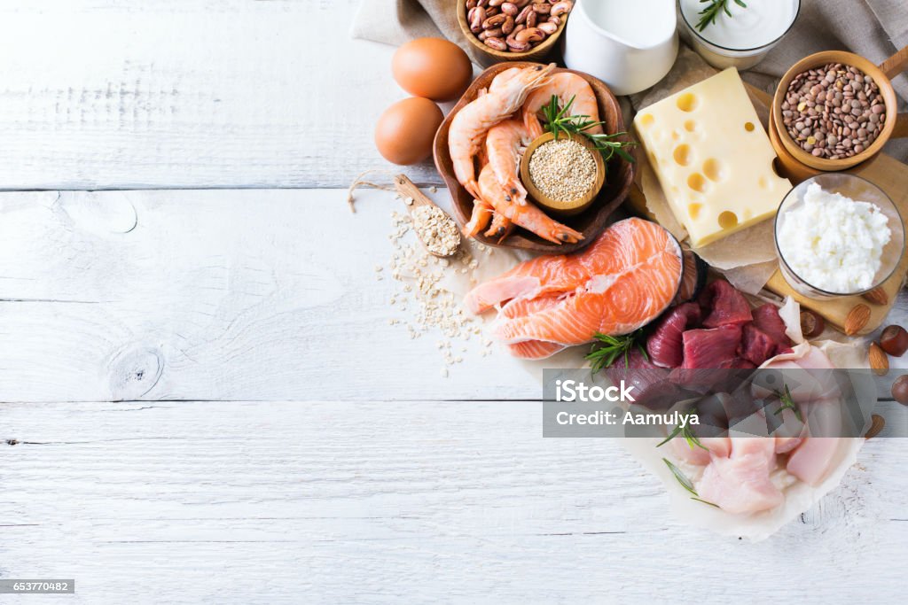 Assortment of healthy protein source and body building food Assortment of healthy protein source and body building food. Meat beef salmon chicken eggs dairy products milk cheese yogurt beans quinoa nuts oat meal. Copy space background, top view flat lay Meat Stock Photo