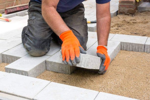 Manos de un constructor colocando nuevos adoquines. - foto de stock