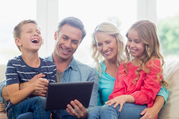 istock Parents and kids using digital tablet in living room 653771146
