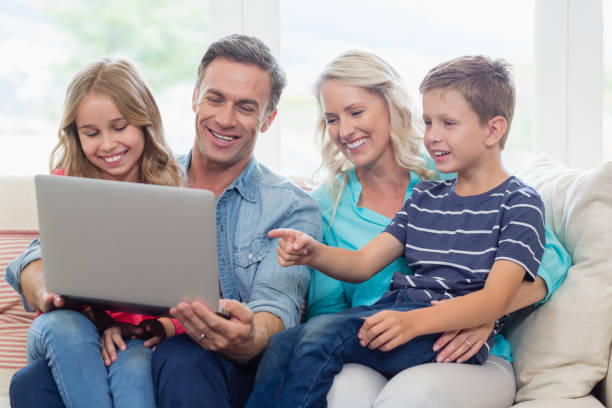 istock Parents and kids using laptop in living room 653771182