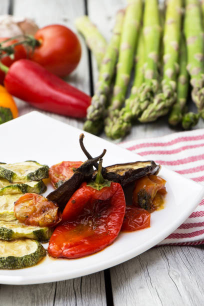 geröstetes gemüse auf dem weißen rustikalen hintergrund. zucchini, auberginen und paprika mit tomatensoße anbraten. - service bell flash stock-fotos und bilder