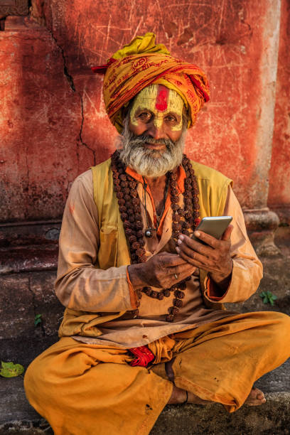 istock Sadhu - indian holyman using mobile phone 653775676