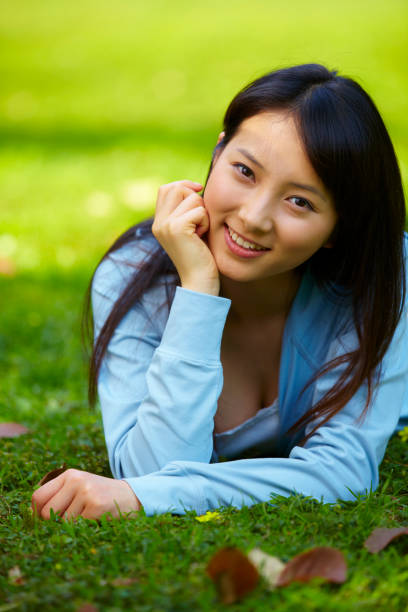 istock One young asian woman lying on the grassland 653776622