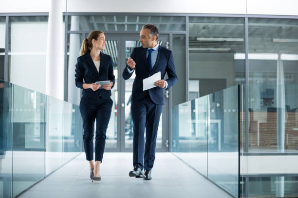 istock Business colleagues interacting with each other while walking in the corridor 653777470