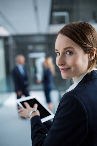 istock Businesswoman using digital tablet in office corridor 653783294