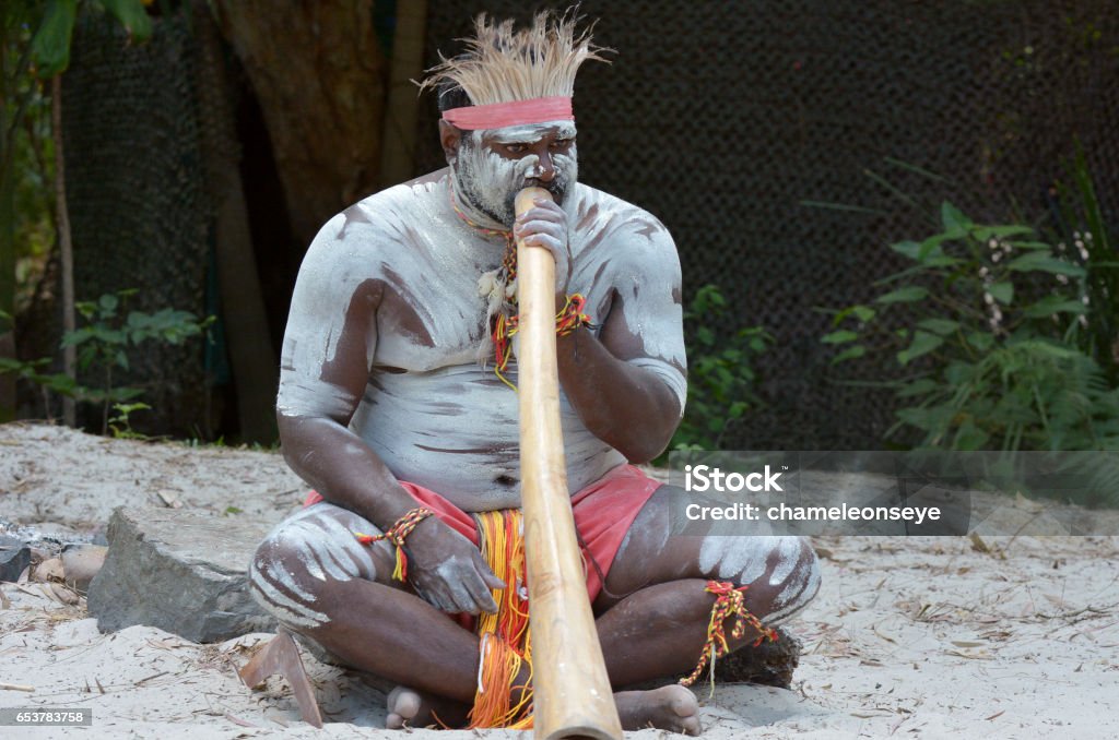 Aboriginal culture show in Queensland Australia Portrait of one Yugambeh Aboriginal man play Aboriginal  music on didgeridoo, instrument during Aboriginal culture show in Queensland, Australia. Didgeridoo Stock Photo