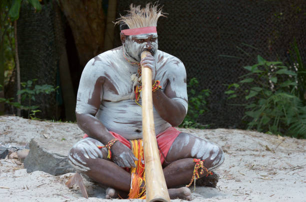 Aboriginal culture show in Queensland Australia Portrait of one Yugambeh Aboriginal man play Aboriginal  music on didgeridoo, instrument during Aboriginal culture show in Queensland, Australia. didgeridoo stock pictures, royalty-free photos & images