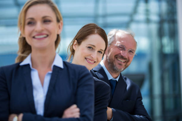 istock Smiling businesspeople standing with hands crossed 653788464