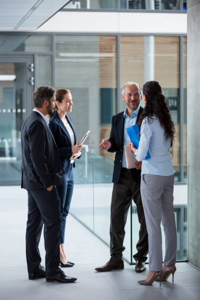 istock Businesspeople having a discussion in office corridor 653788536