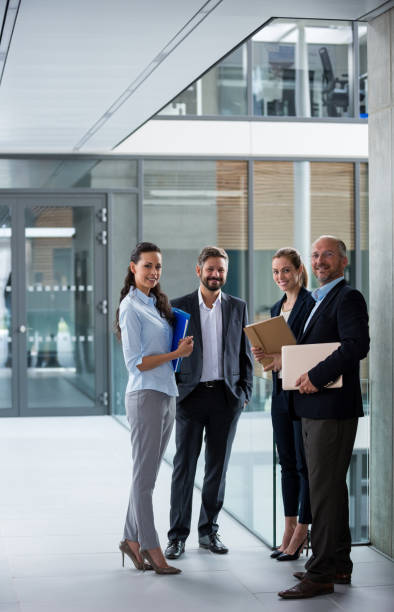 istock Happy businesspeople standing in office corridor 653788910