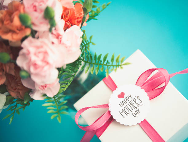 Mother's Day arrangement with gift and fresh carnations Mother's Day arrangement with gift and fresh carnations gift tag note photos stock pictures, royalty-free photos & images