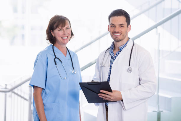 istock Nurse and doctor discussing over clipboard in corridor 653791874