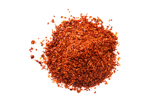 Pile of Aleppo Flakes red pepper isolated on white background selective focus
