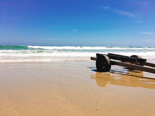 istock The wheelbarrow on the beach with sea wave foam 653797768