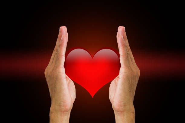 istock Man's hands holding red heart on dark background 653801486