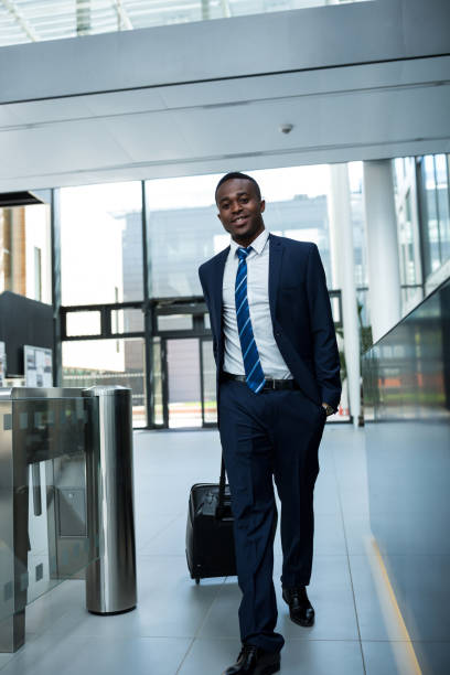 istock Happy businessman walking holding suitcase 653802558