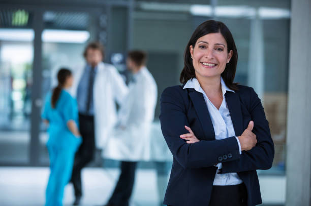 Businesswoman with hands folded Portrait of a businesswoman standing with hands folded at the hospital premises sales executive stock pictures, royalty-free photos & images