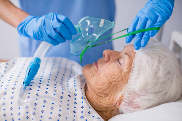 доктор надеть кислородную маску на пациента - medical oxygen equipment healthcare and medicine 70s mature adult стоковые фото и изображения