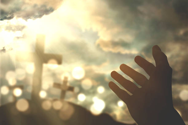 istock Human hands praying with cross symbol 653807662