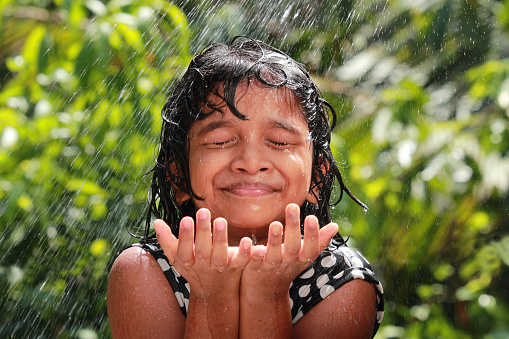 Little girl plays with water in the outdoor