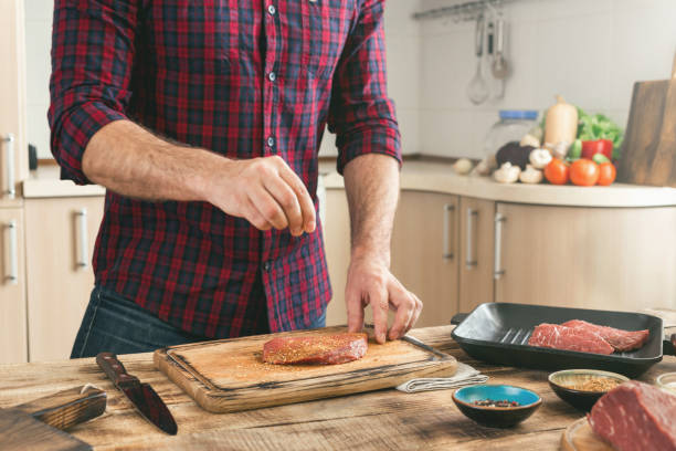 istock Man cooking grilled steak on the home kitchen 653808588